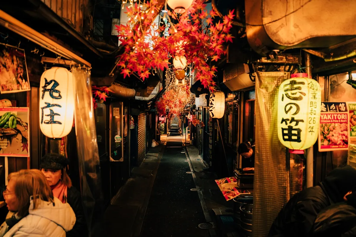 Cozy lantern-lit alleyway in Japan with warm glowing paper lanterns along a narrow traditional street