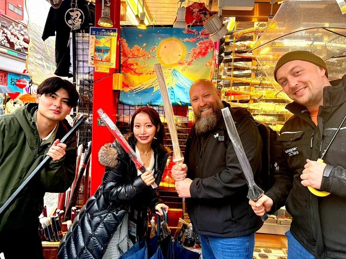 Tour guide leading guests past a traditional Asakusa sweet shop with street food displays
