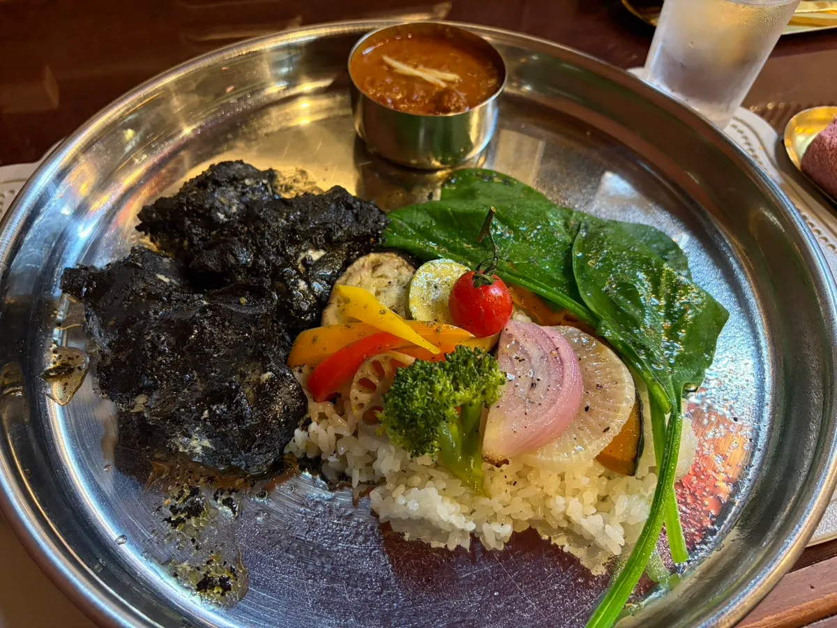 Curry rice plate with dark roux, fresh vegetables, and rice on a steel plate at a Kanazawa restaurant