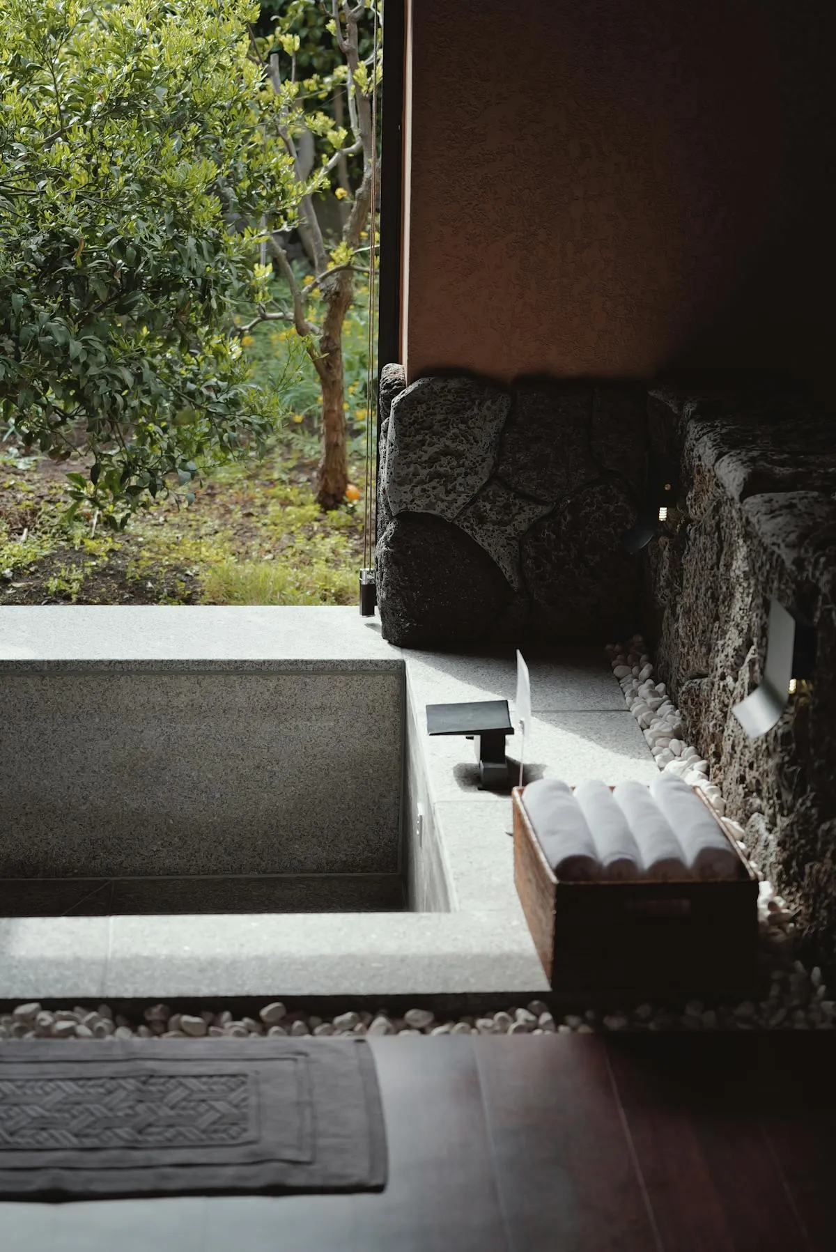 Stone soaking tub in a Japanese ryokan with a garden view through the open window
